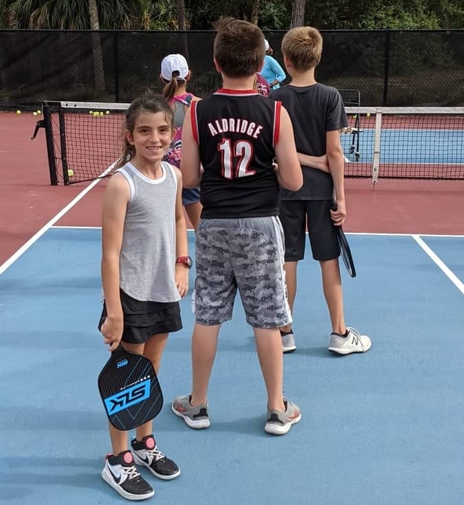 a group of people standing on a court with a racket